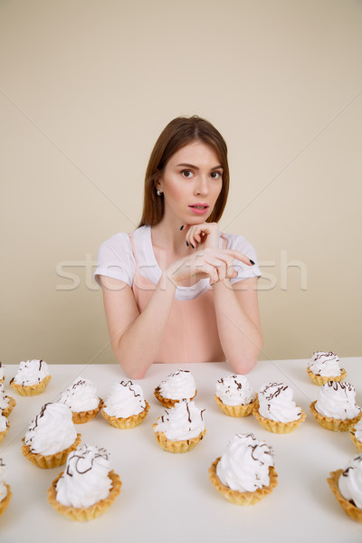 Vertical image of young woman by the table with cakes Stock photo © deandrobot