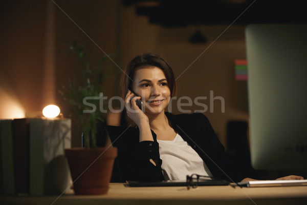 Happy young woman designer talking by phone Stock photo © deandrobot