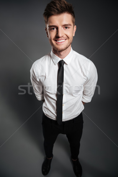 Full length portrait of a happy handsome man in formalwear Stock photo © deandrobot