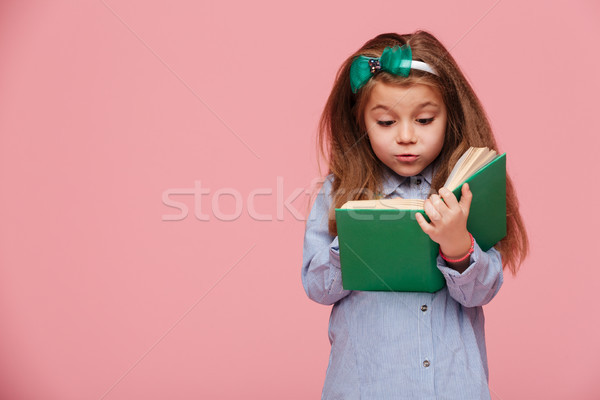 Image of cute girl 5-6 years with long auburn hair reading inter Stock photo © deandrobot
