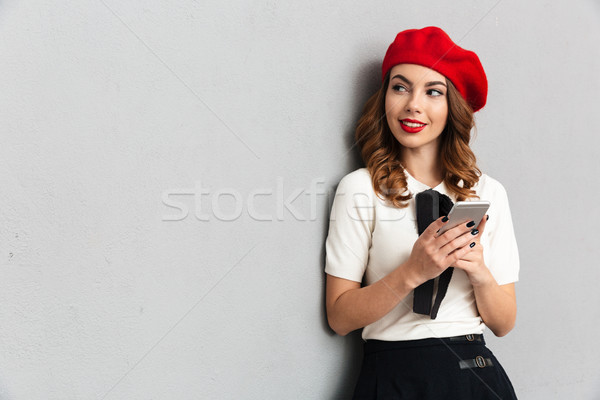 Portré mosolyog iskolás lány egyenruha tart mobiltelefon Stock fotó © deandrobot