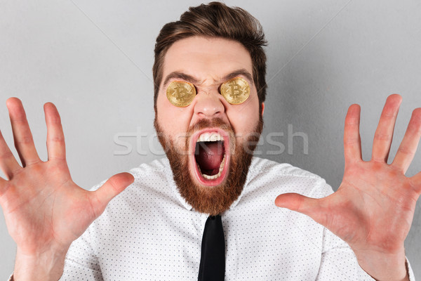 Close up of an excited businessman with bitcoins Stock photo © deandrobot