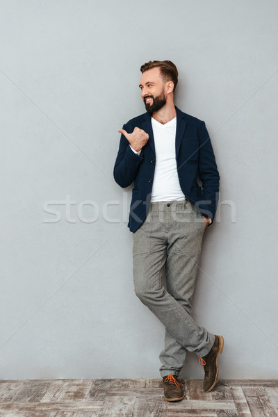 Full length image of smiling bearded man in business clothes Stock photo © deandrobot