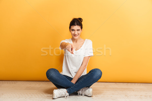 Portrait souriant jeune femme séance jambes croisées étage [[stock_photo]] © deandrobot