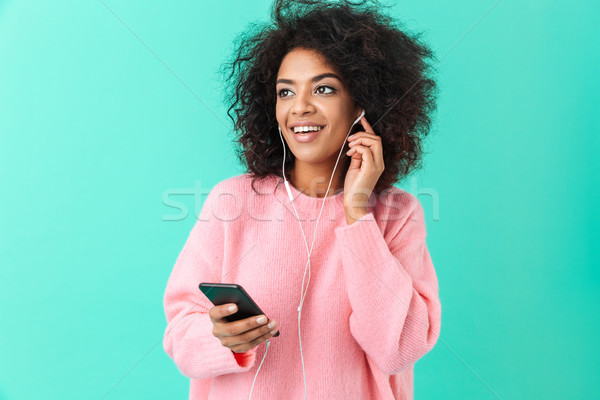 Portrait of content woman in casual clothing listening to music  Stock photo © deandrobot