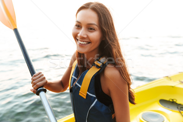 Beautiful woman kayaking on lake sea in boat. Stock photo © deandrobot