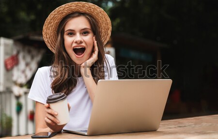 Izgatott fiatal lány iszik kávé ül laptop számítógép Stock fotó © deandrobot