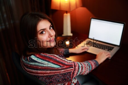 Young happy woman sitting at the table at home Stock photo © deandrobot