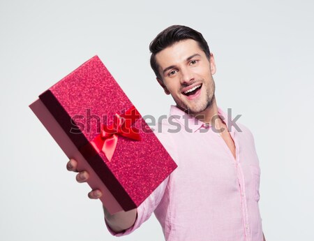 Happy young man holding gift box Stock photo © deandrobot