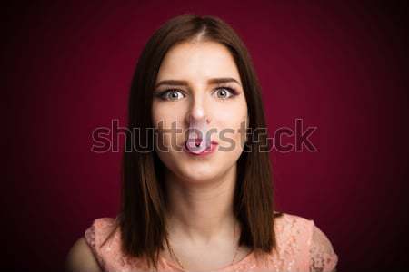 Woman blown up bubble gum on her nose and mouth Stock photo © deandrobot