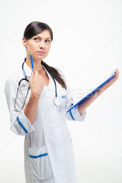 Pensive medical doctor holding clipboard Stock photo © deandrobot