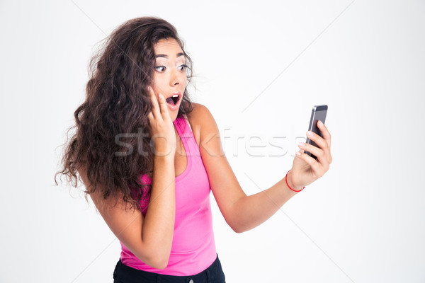 Surprised woman looking on smartphone Stock photo © deandrobot