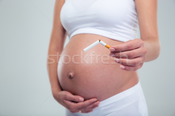 Pregnant woman breaking a cigarette Stock photo © deandrobot