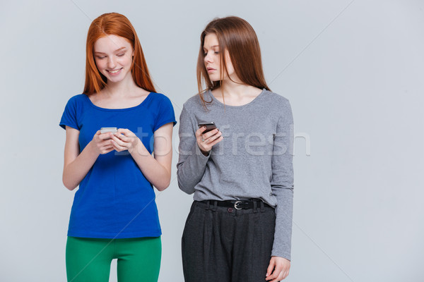 Doua zâmbitor deprimat femeile tinere în picioare Imagine de stoc © deandrobot