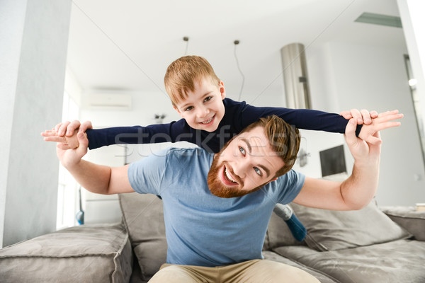 Happy father playing with his little cute son in room Stock photo © deandrobot