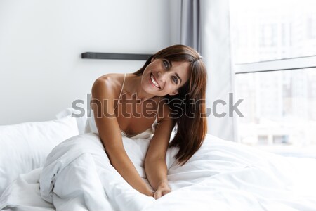 Gülen şehvetli genç kadın oturma yatak yatak odası Stok fotoğraf © deandrobot