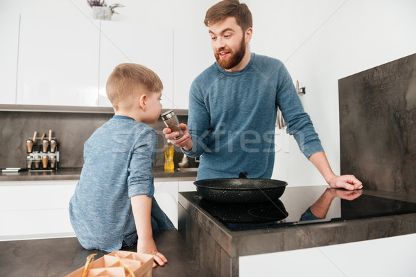 Bearded father cooking at kitchen with his cute son Stock photo © deandrobot