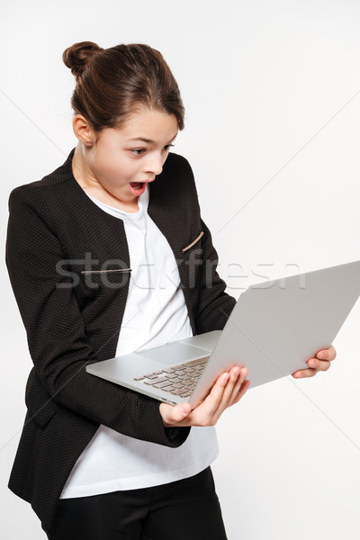 Shocked young girl standing with laptop Stock photo © deandrobot