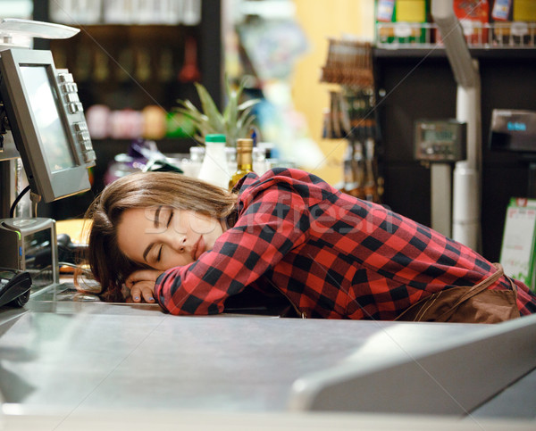 Cashier lady sleeping on workspace in supermarket shop. Stock photo © deandrobot