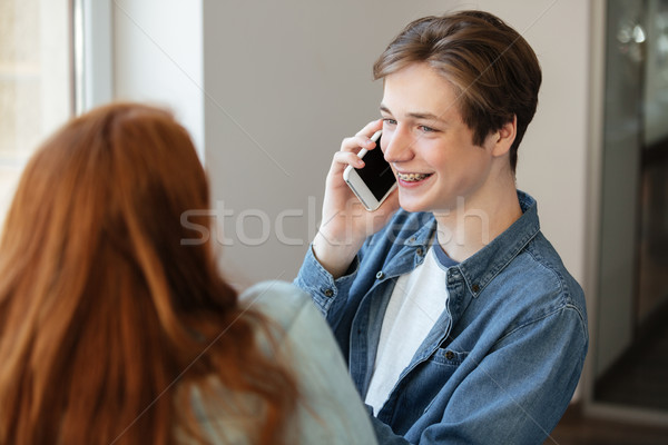Fiatal diák telefon barát derűs beszél Stock fotó © deandrobot