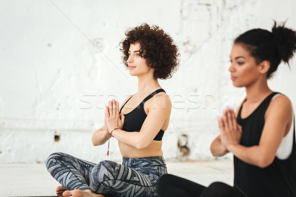 Group of women sitting on a yoga mats Stock photo © deandrobot
