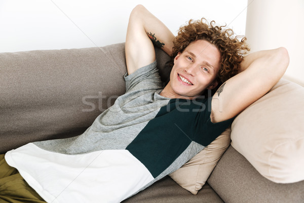 Сток-фото: красивый · улыбаясь · человека · Ложь · диван · изображение