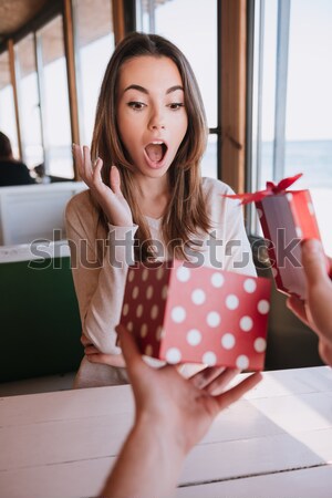 Happy young woman choosing shoes and pointing. Stock photo © deandrobot
