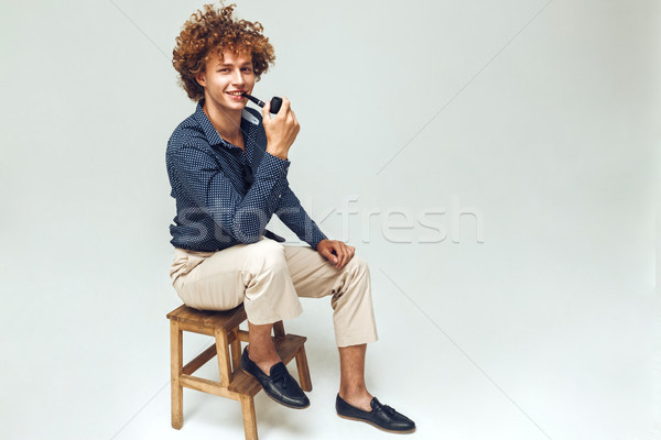 Positive retro man dressed in shirt sitting and posing Stock photo © deandrobot