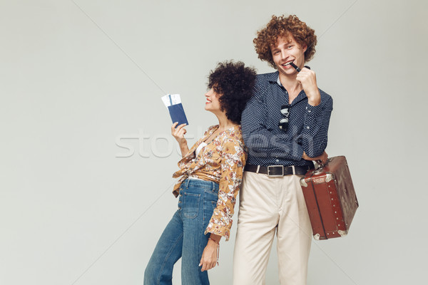 Retro loving couple holding suitcase passport and tickets. Stock photo © deandrobot