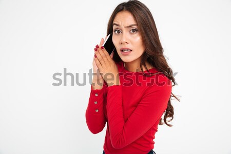 Portrait of a confused asian woman covers mobile phone Stock photo © deandrobot