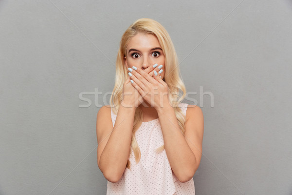 Portrait of a terrified woman covering mouth Stock photo © deandrobot
