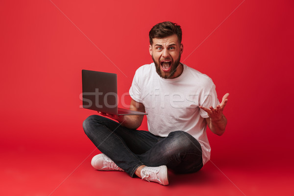 Photo of displeased bored man in t-shirt and jeans screaming and Stock photo © deandrobot