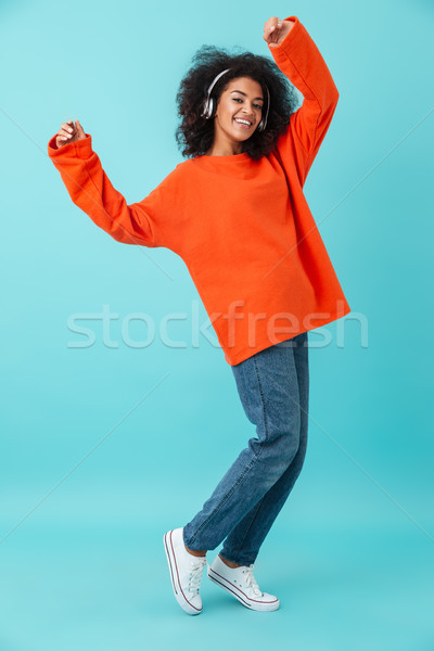 Foto amerikaanse glimlachende vrouw oranje shirt Stockfoto © deandrobot