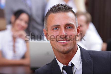 Portrait of a happy senior business man at office with his business team working behind Stock photo © deandrobot