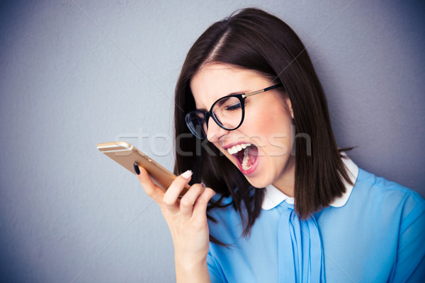 Mérges üzletasszony kiált okostelefon visel kék Stock fotó © deandrobot