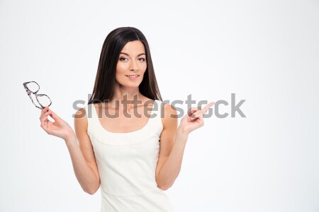 Woman holding glasses and pointing finger away Stock photo © deandrobot