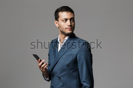 Stock photo: Businessman using smartphone and looking at camera