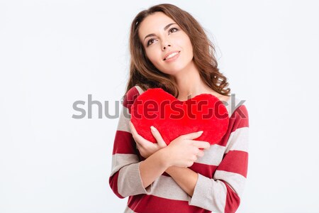 Happy thoughtful woman holding red heart and looking up Stock photo © deandrobot