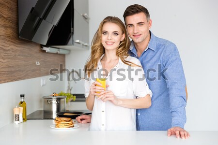 Beautiful couple mixing products in glass bowl with hand beater  Stock photo © deandrobot