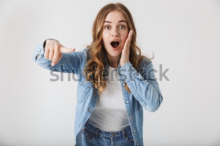 Amazed pretty woman with opened mouth and hands on head  Stock photo © deandrobot