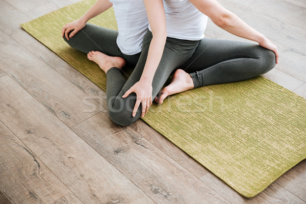 Two young women practicing yoga on green mat in studio Stock photo © deandrobot