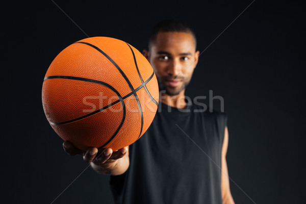 Concentrated young serious african sports man giving basket ball Stock photo © deandrobot