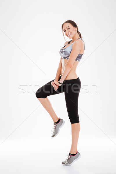 Full length fitness woman stands sideways Stock photo © deandrobot