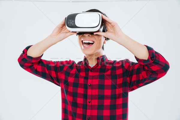 Happy man wearing virtual reality device Stock photo © deandrobot