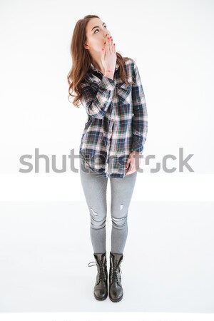 Amazed woman covered her mouth with hand and looking away Stock photo © deandrobot
