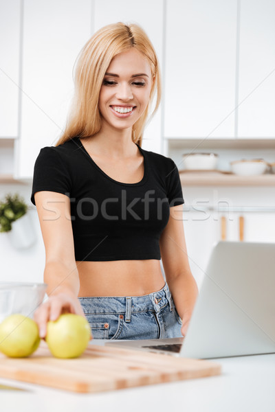 Vertical image of woman with apple and laptop Stock photo © deandrobot
