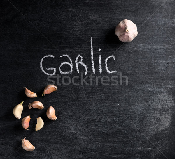 Garlic over dark chalkboard background Stock photo © deandrobot