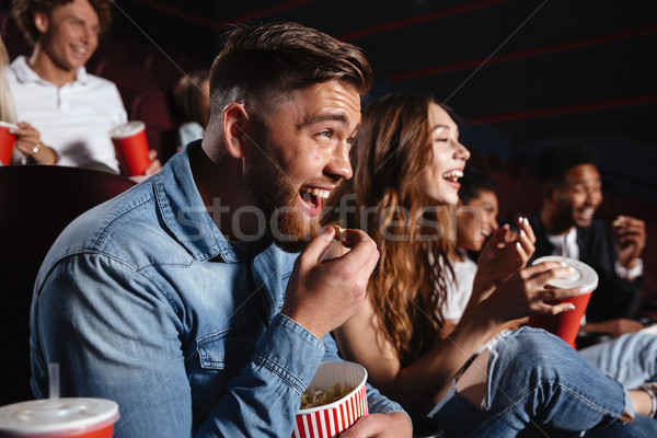 Laughing friends sitting in cinema watch film Stock photo © deandrobot