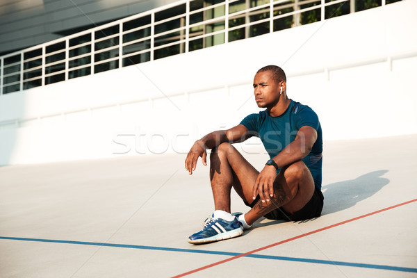 Portrait of a concentrated african fitness man in earphones Stock photo © deandrobot