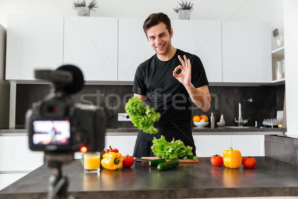 Smiling young man filming his video blog episode Stock photo © deandrobot